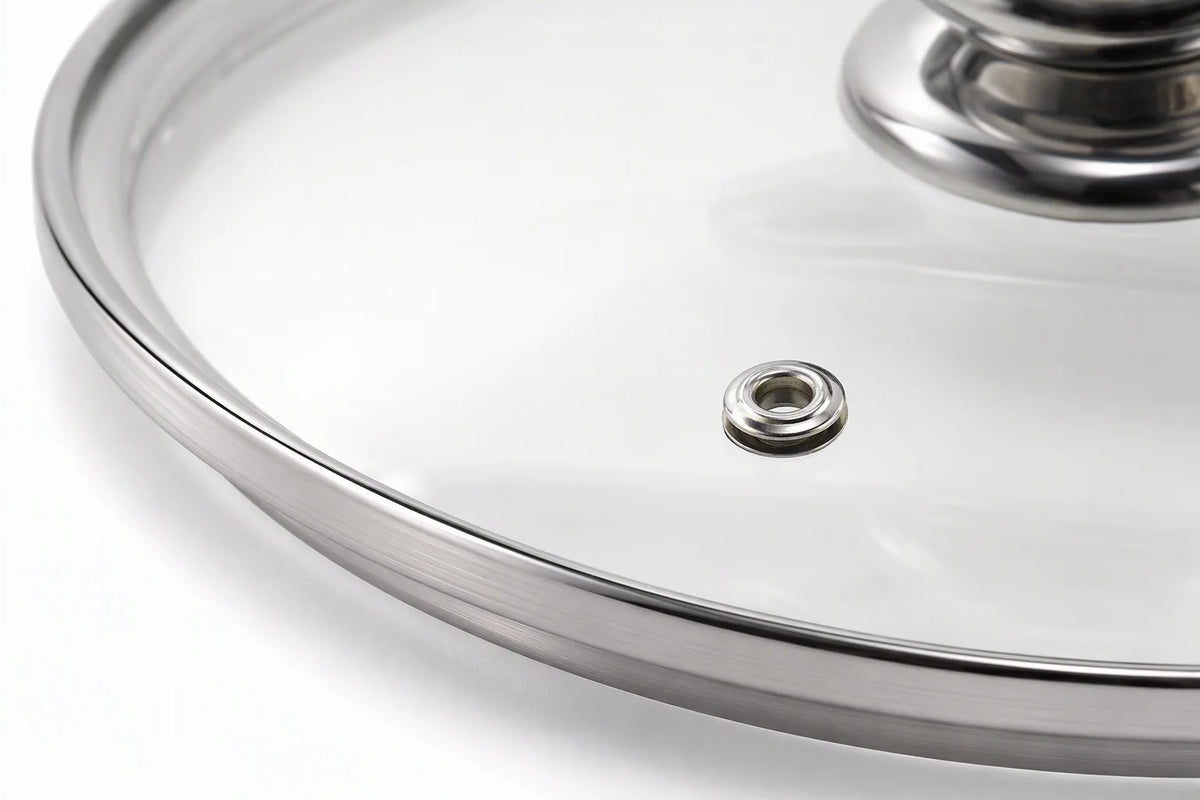 Close-up macro shot of premium tempered glass cookware lid showing polished stainless steel rim detail and steam vent