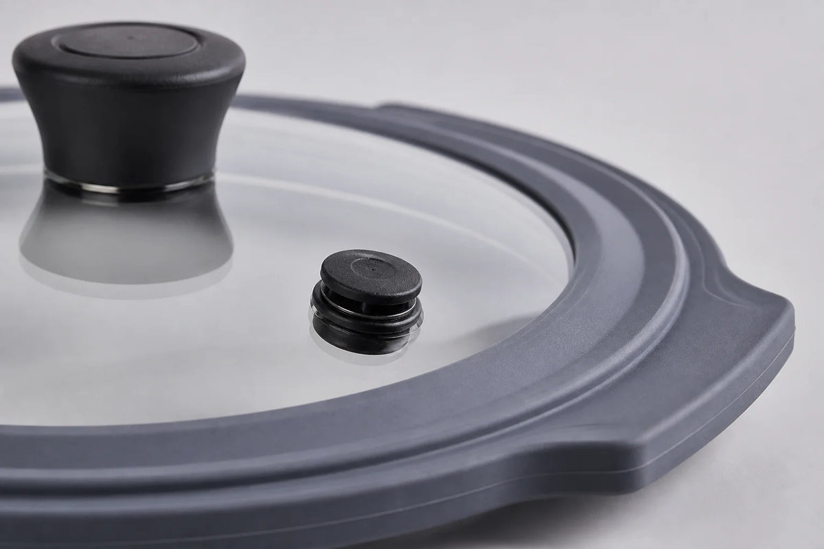 Close-up studio shot of a tempered glass cookware lid engineered with a food-grade silicone rim gasket for multi-cookers